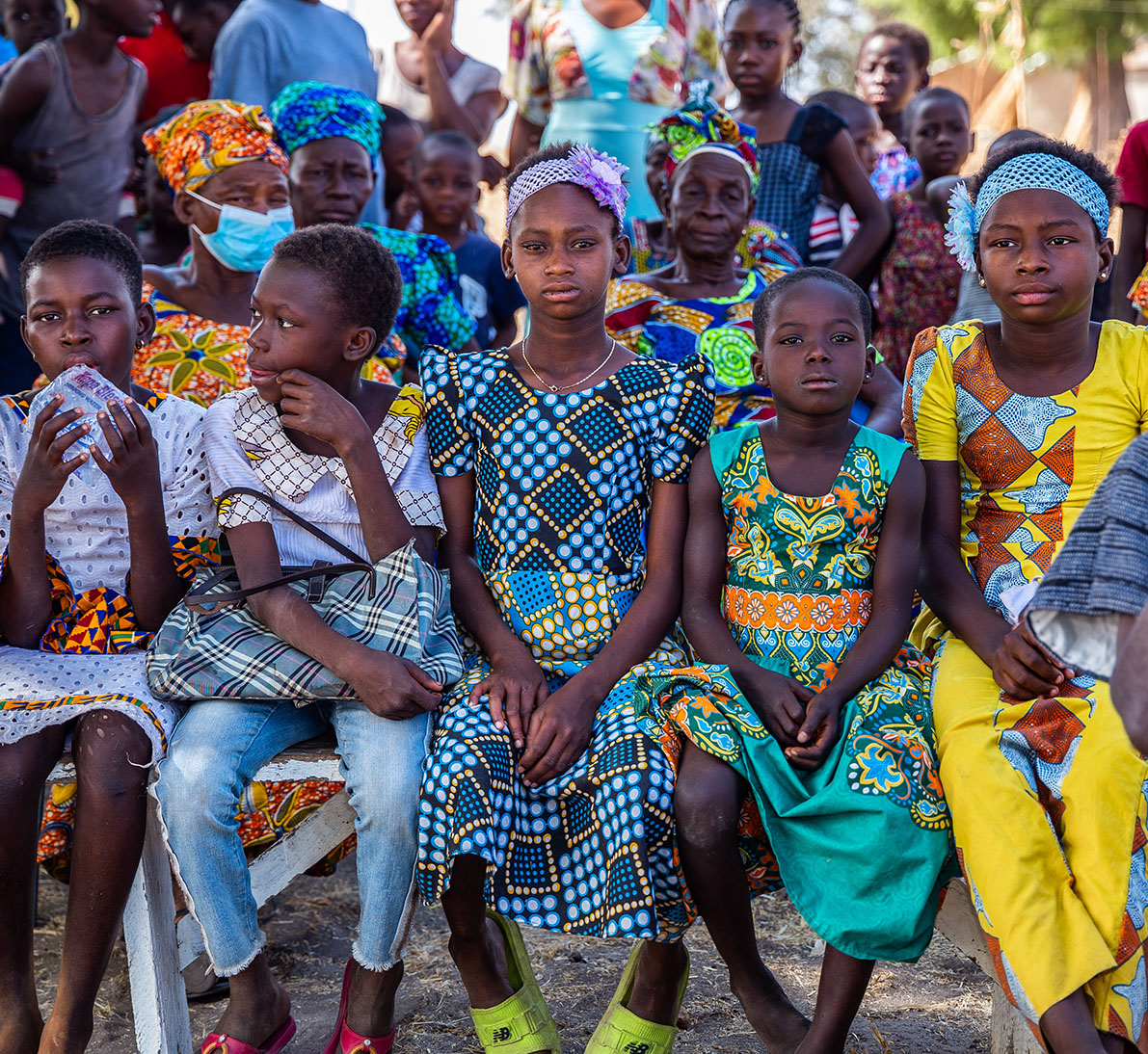 Young Ghanaian children in a crowd wearing colorful clothing