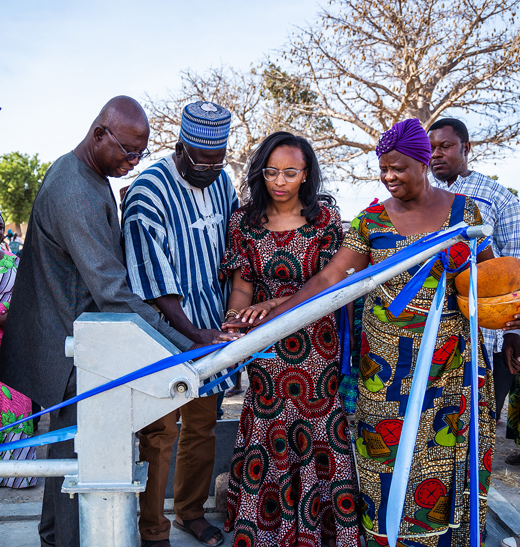 Four people praying over a new water well