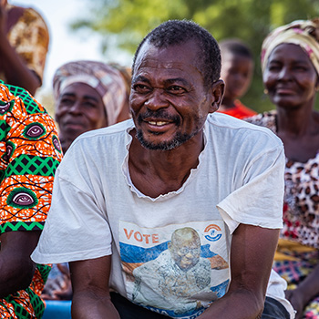 A photo of a smiling Ghanaian man wearing a gray shirt.