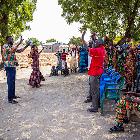 A photo of a crowd raising their hands in Ghana.