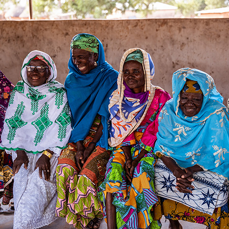 Four smiling Ghanaian women wearing head scarves